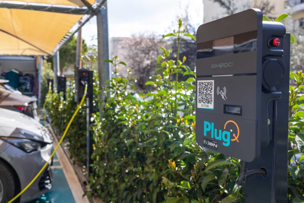 Σταθμός φόρτισης PlugQ με ηλεκτρικό όχημα σε υπαίθριο χώρο